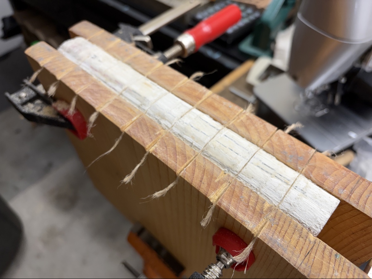 Bible spine being reinforced in the workshop press